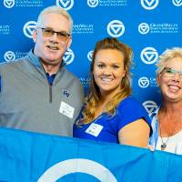 Three alumni pose for a photo